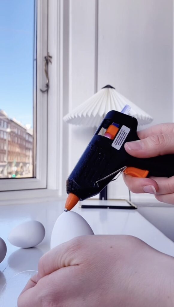 Lim nylonsnoren fast på pynteægget. 